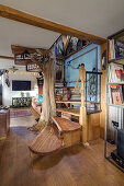 Wooden staircase and tree trunk in open plan living room