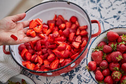 Making strawberry jam - put cleaned and chopped strawberries in pot