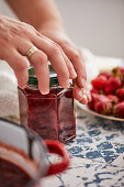Sealing a jar with homemade strawberry jam