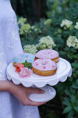 Donuts with pastel icing on a cake stand