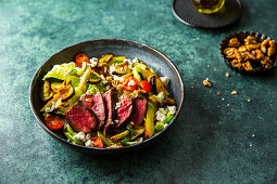 Coffee-marinated steak on grilled vegetable salad with nuts and feta