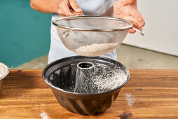 Dusting a gugelhupf tin with flour
