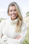 Young blonde woman in white turtleneck in nature