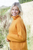 Young blonde woman in yellow turtleneck in nature