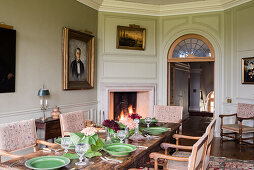 Set table with green porcelain dishes and antique chairs in the dining room