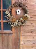 Vine wreath with dried flowers as door decoration