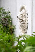 Wasserspeier mit Löwenkopf im Garten