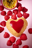 A heart-shaped biscuit with passion fruit and raspberries