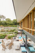 Terrasse mit Sofa und Esstisch am Architektenhaus mit großem Garten