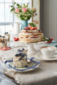 Layered Pancake, strawberry, and cream cake, and blueberry-cherry muesli on a breakfast table