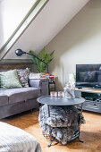 Grey upholstered sofa, TV furniture, and coffee table with basket for throw pillows in the attic room