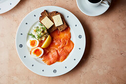 Frühstücksteller mit Lachs, gekochten Eiern und Roggenbrot