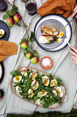 Salat mit Eiern, Mayonnaise, Sardellen und Schnittlauch und gebratener Schweinebauch mit Fenchel