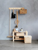 Storage boxes on wooden shelves below cleaning utensils hung on a peg rack