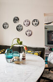 Fornasetti decorative plates hung above the bench in the dining area