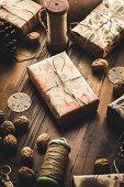 Christmas resents, a spool of yarn, walnuts and pine cones on a wooden table