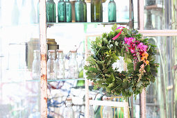 Oak leaf wreath with colorful flowers on vintage shelf