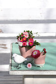 Small bouquet of bellis and decorative bird
