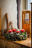 Advent wreath made of natural materials with red candles on a windowsill