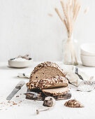 Mustard crust bread, partly sliced on a wooden board