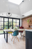 Custom-made concrete table and classic chairs in front of sliding glass doors