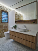 A washbasin with a mirrored cabinet above it in a bathroom