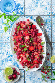 Red fruit salad with berries, cherries and melon