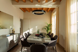 A light-flooded dining room with brown leather chairs