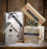 Festlich verpackte Geschenke mit Namensschildern und einem Vogelhäuschen