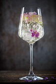 Ein Glas Riesling mit Blüten und Eiswürfeln