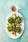 Vegan wild herb salad in grilled avocado and miso dressing