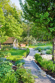 Leicht gewundener Kiesweg im frühlingshaften Garten