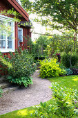 Shrubs along the gravel path and in front of the house