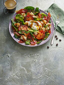 Brunch salad with poached egg, bacon and roasted tomatoes