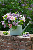 Bouquet of tulips (Tulipa) and lilac flowers (Syringa) in old watering can