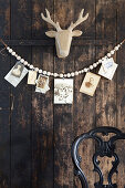 DIY garland of wooden balls with vintage photos on wooden wall