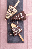 Vegan vanilla cheesecake on sticks coated with light and dark chocolate