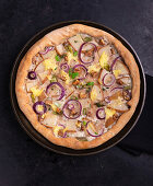 Vegan pizza with pears, onions, and walnuts