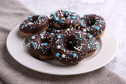 Vegan cinnamon donuts with dark chocolate icing and wintry sugar decorations