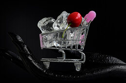Mini shopping cart with ice cubes and a cherry