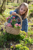 Kleines Mädchen mit Osterkorb im Garten
