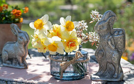 Blumenstrauß aus Narzissen (Narcissus) und blühende Zweige der Felsenbirne (Amelanchier) in Vase und Osterdekoration