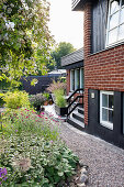 Flowerbeds on gravel path along the house