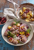 Skandinavische Frikadellen mit Kartoffeln und roten Zwiebeln