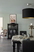 Dining area with dark furniture, glass cabinet in the background