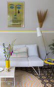 White sofa with vintage poster above in the conservatory