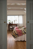 View through open sliding doors into the bedroom with exposed beams