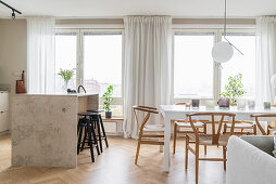 Kitchen island with bar stools and dining area in light-flooded living room