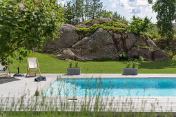 Blick über Pool auf Felsen im Garten