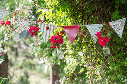 Pennant chain decorated with rose bouquets and strawberry branches in glass vases